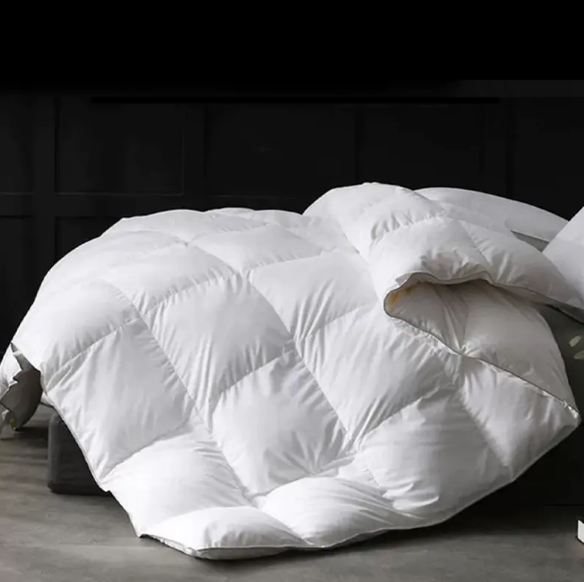 What are the advantages of using down as a filling material for hotel quilts?